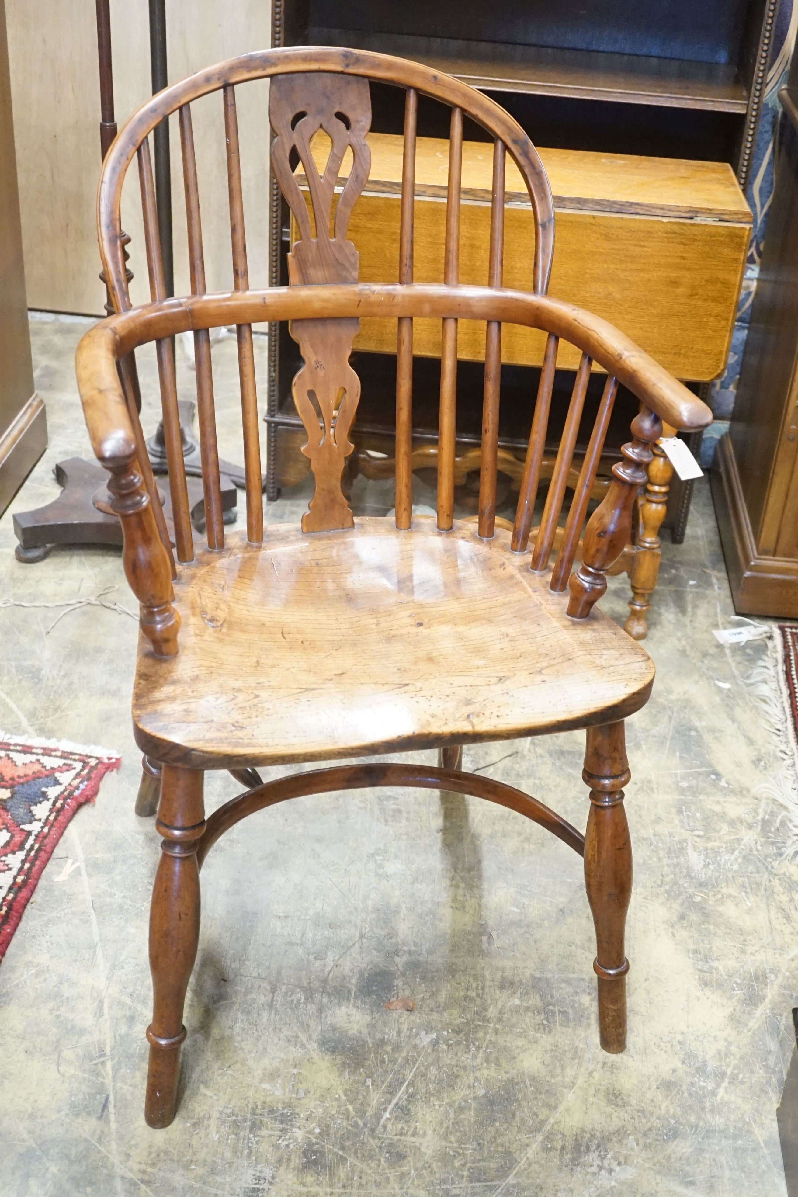 A near pair of mid 19th century Nottingham Area yew and elm Windsor elbow chairs with crinoline stretchers